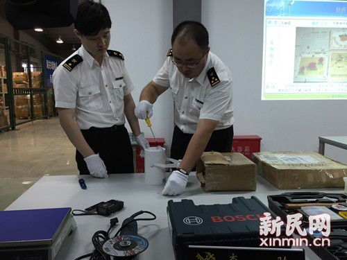 图说：对高度怀疑快件，海关人员开箱查验，在LED灯箱中藏有结晶物品。新民晚报新民网记者